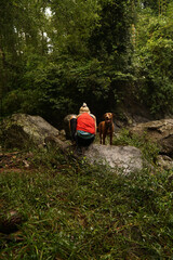 A blonde woman walking with the dogs around the river.