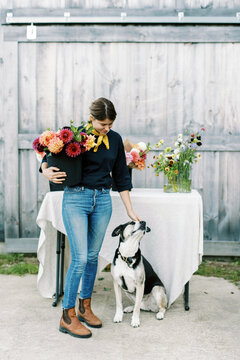 florist standing in front of her barn with fresh cut annuals