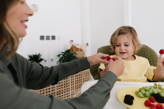 Mother and boy playing with raspberries