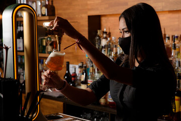 young girl serving a glass of beer in a bar. waitress concept