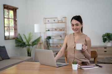 Beautiful woman sittng in her house while working remotely for the office.