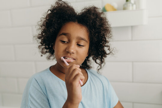 Charming girl brushing teeth in morning