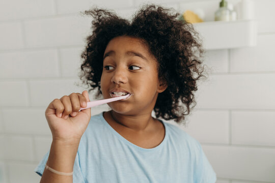 Black kid brushing teeth in morning at home