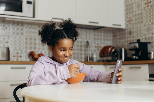 Black with smartphone smiling during breakfast