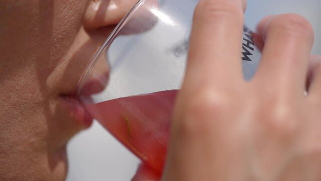 Woman Drinks Red Wine From A Glass At Summertime. Extreme Close Up
