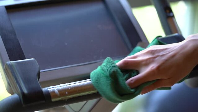 Wiping And Disinfecting The Monitor Of Treadmill In The Gym.