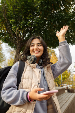 Happy woman greeting friend in park