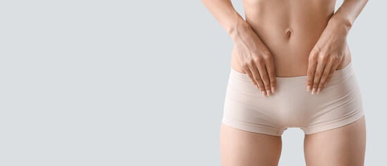 Slim young woman in underwear on light background with space for text, closeup