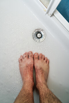 man's feet in the shower