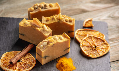 Natural orange soap on the black and wooden background. Concept of making and using organic eco soap and cosmetics