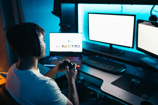 Young man playing video games online on pc