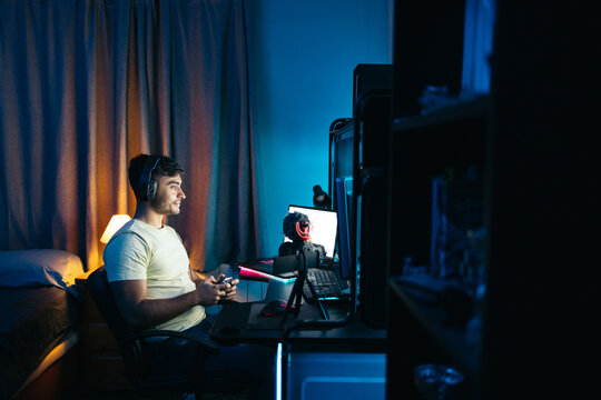Young man playing video games online on pc