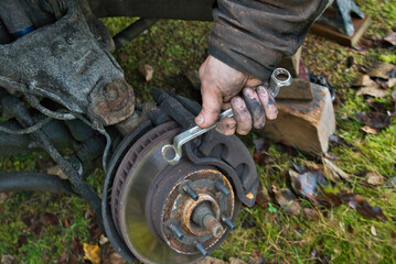 Home auto mechanic fixing brake pads on a car.