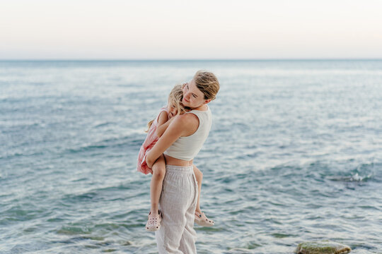 Woman Embracing Child On Beach