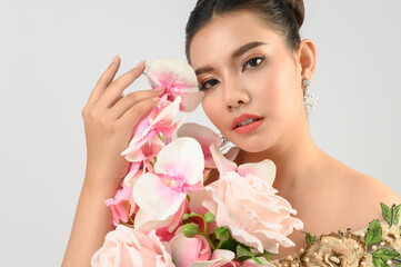 Young asian beautiful bride with orchid bouquet on white background