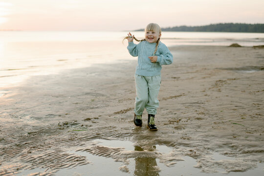 Cute happy girl posing on a sandy beach