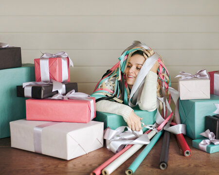 Young woman resting after packing lots of Christmas gifts. 