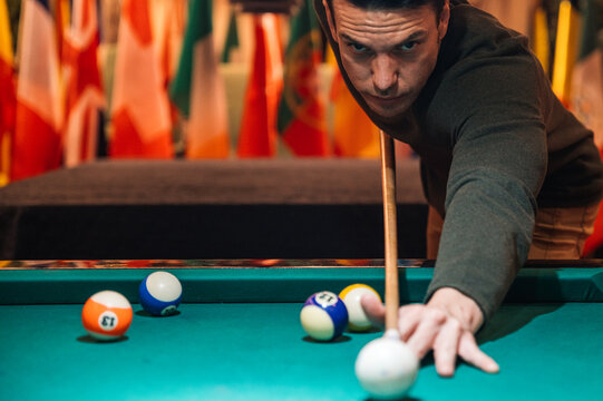 Focused sportsman playing pool in club