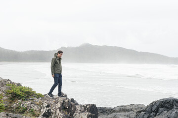 Young man hiking in casual rain gear