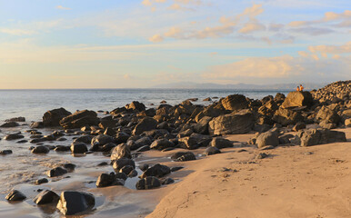 Rocks on a beach facing the sun.