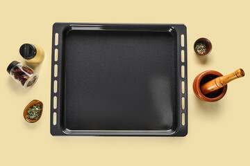 Baking tray with spices, mortar and pestle on beige background
