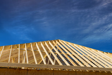 Using an frame of trusses framework, stick wooden roof beam install it on newly built home - obrazy, fototapety, plakaty