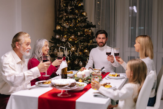 Family celebrate Xmas tree table dinner toast together wish