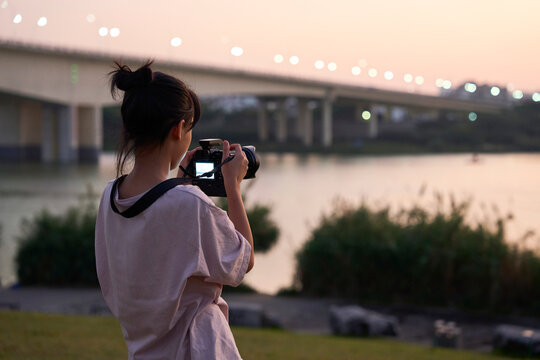 Asian little girl photographer, practising photography outdoors