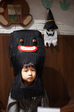 Adorable little asian boy at party with halloween spooky headdress
