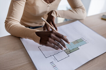 Crop black architect examining draft