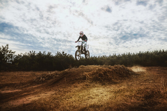 Young Man on Dirt bike jump in blue sky