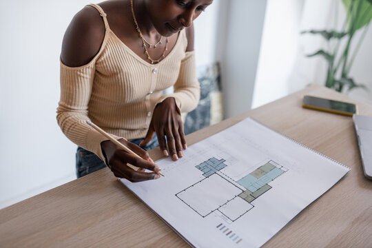Black architect reading draft and notes