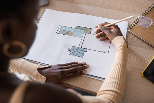 Crop black architect working with draft