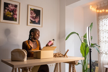 Happy black influencer reviewing skin care product