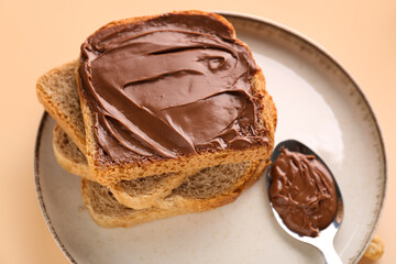 Plate of tasty toasts with hazelnut butter on color background, closeup