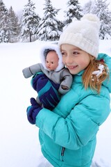 child hugging her doll in winter