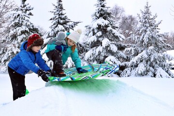 children getting on sled in winter