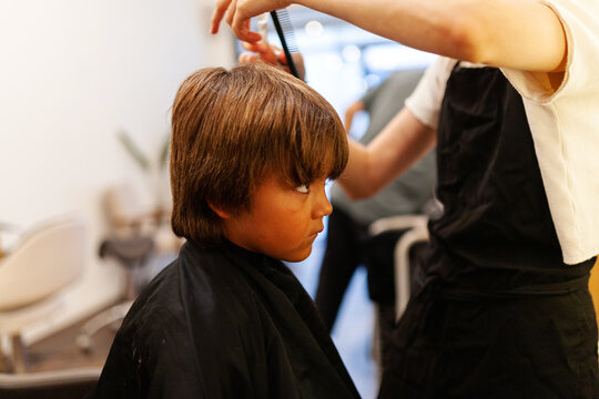 Boy getting haircut at barbershop