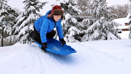 Fototapeta na wymiar boy sledding in the winter