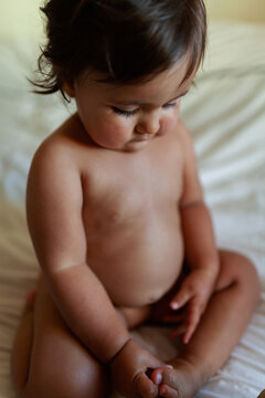 Cute unclothed baby girl on the bed