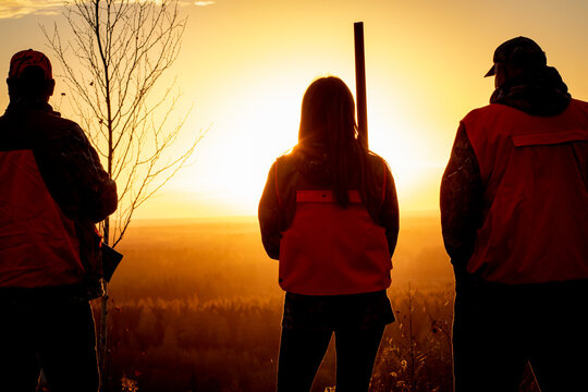 Rear view of three people going hunting, Minnesota, USA