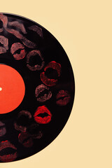 Vinyl record with lipstick kiss marks on yellow background