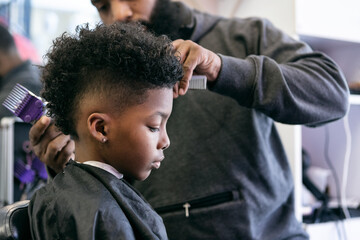 Barber: Side View Of Boy Sitting For Haircut