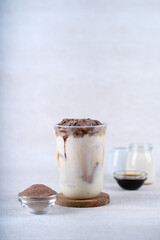 Iced chocolate milk smoothie cocktail with oatmeal on white rustic background