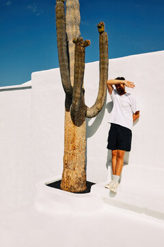 young boy next to a cactus in full sun