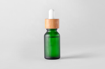 Glass bottle with natural serum on light background