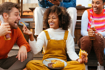 Diverse friends with food having fun in a rooftop