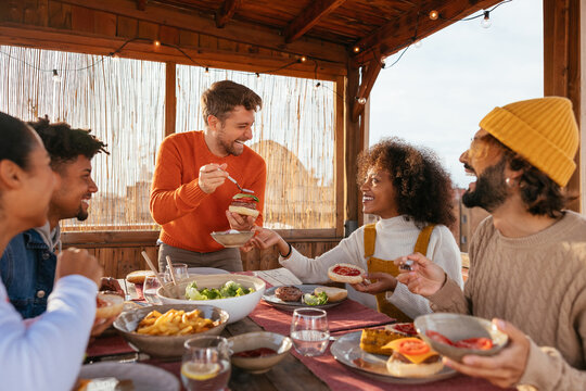 Cheerful diverse friends having dinner in a rooftop