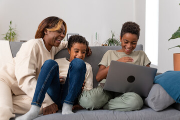 Happy mother and sons watching video together