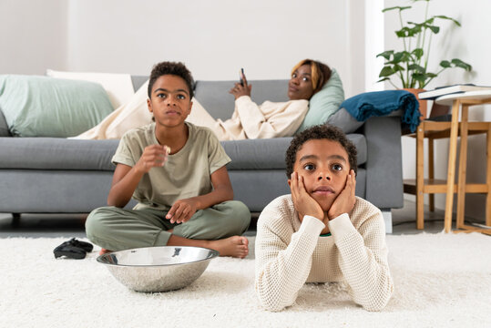Mother and son watching boy playing videogame